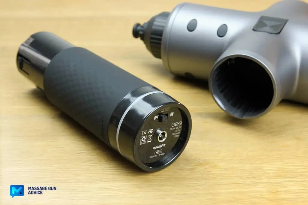 Ultimate Guide to Charging Your Massage Gun: Best Practices and Essential Tips 1 a massage gun on a table beside its detachable battery