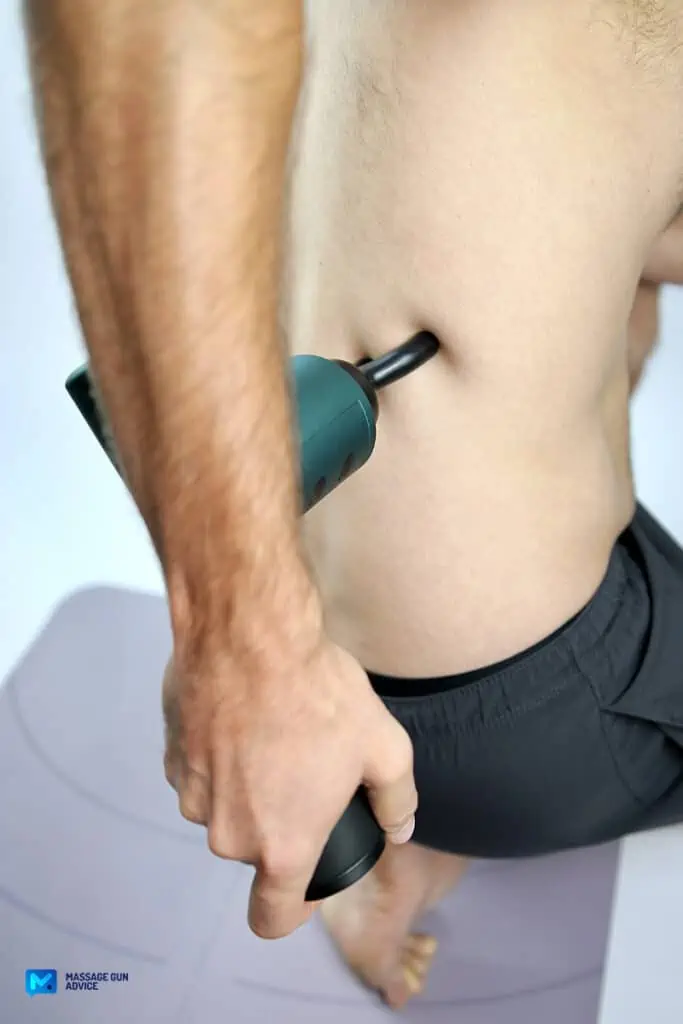 What Toxins Are Released After Massage? Demystifying Detoxification 6 how to flush toxins out of your body: man holding massage gun on his back