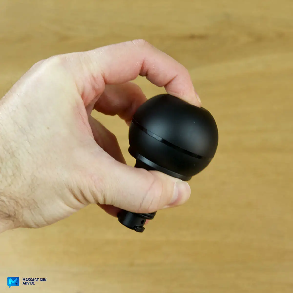 Ekrin Kestrel Review - Is This the Ultimate Massage Gun Unicorn? 24 A hand holding an Ekrin Kestrel massage gun attachment known as Ball Head - a finger is pressing the head