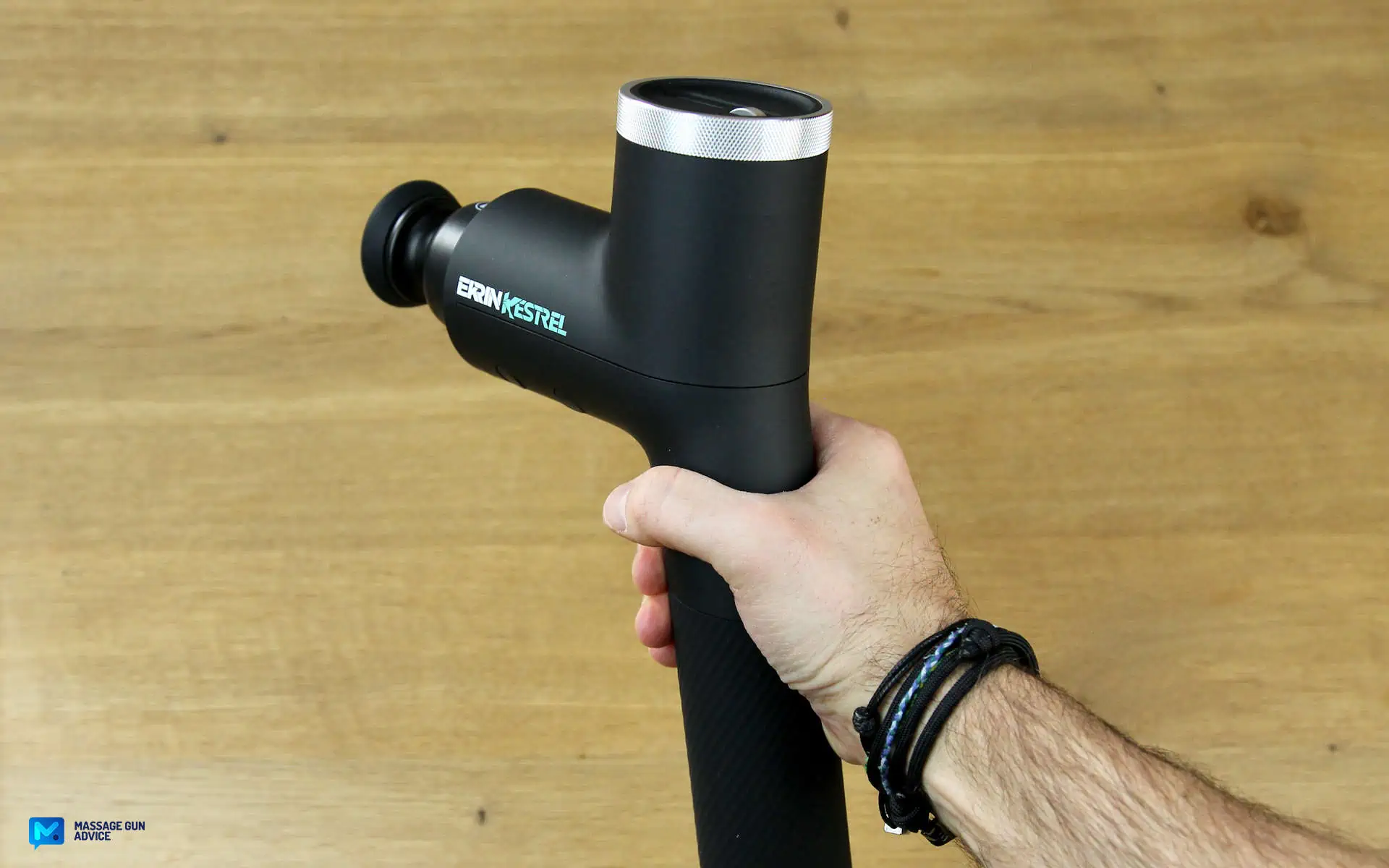 Ekrin Kestrel Review - Is This the Ultimate Massage Gun Unicorn? 16 Ekrin Kestrel held by Hand on a wood-like background