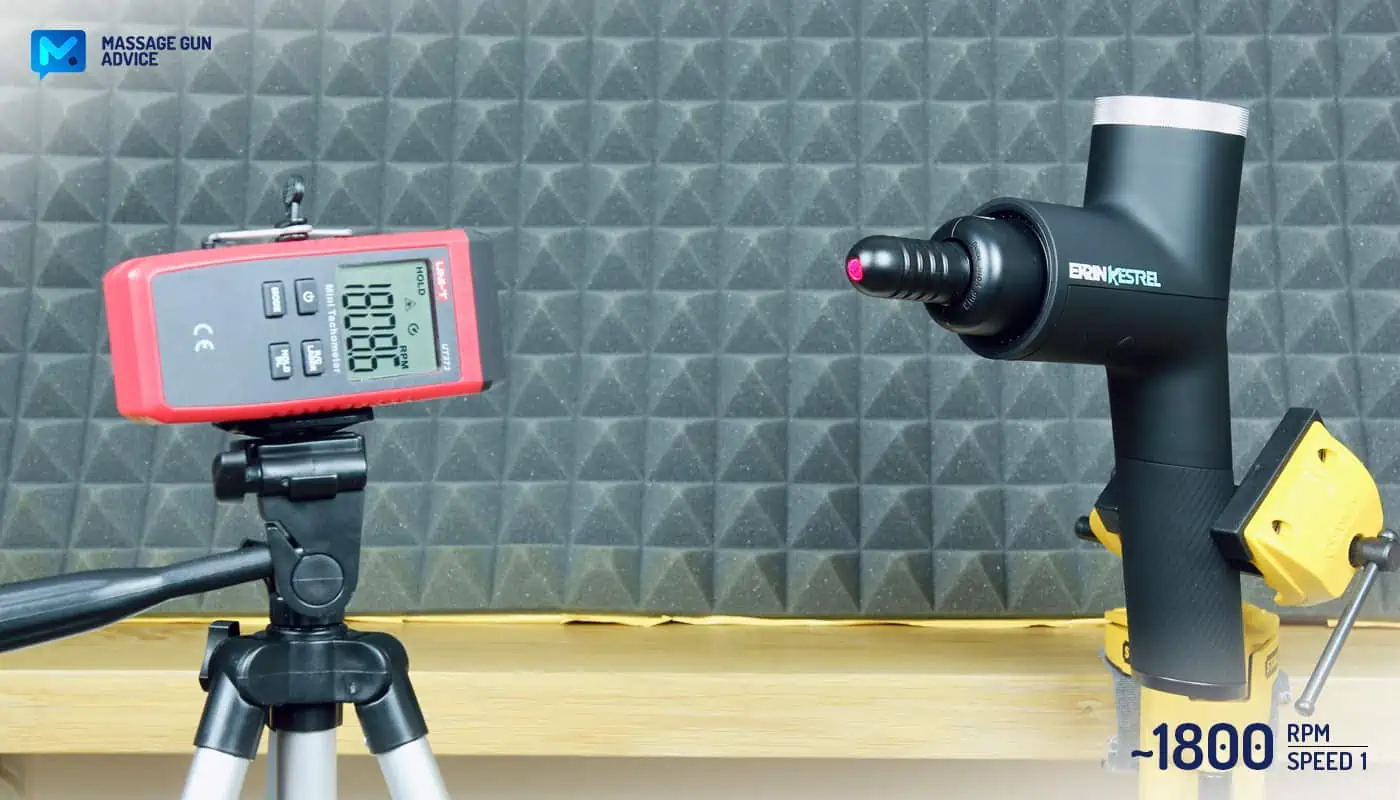 Ekrin Kestrel Review - Is This the Ultimate Massage Gun Unicorn? 31 Ekrin Kestrel clamped to a table while operating at its lowest speed. Opposite to it, a digital tachometer on a tripod to measure RPMs