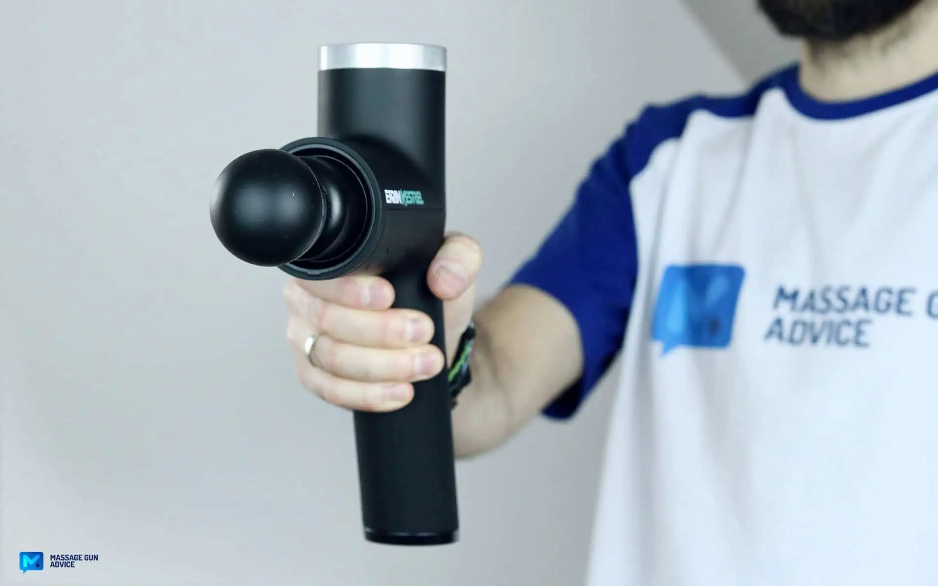 Ekrin Kestrel Review - Is This the Ultimate Massage Gun Unicorn? 35 ekrin Kestrel held by a man on blurred background