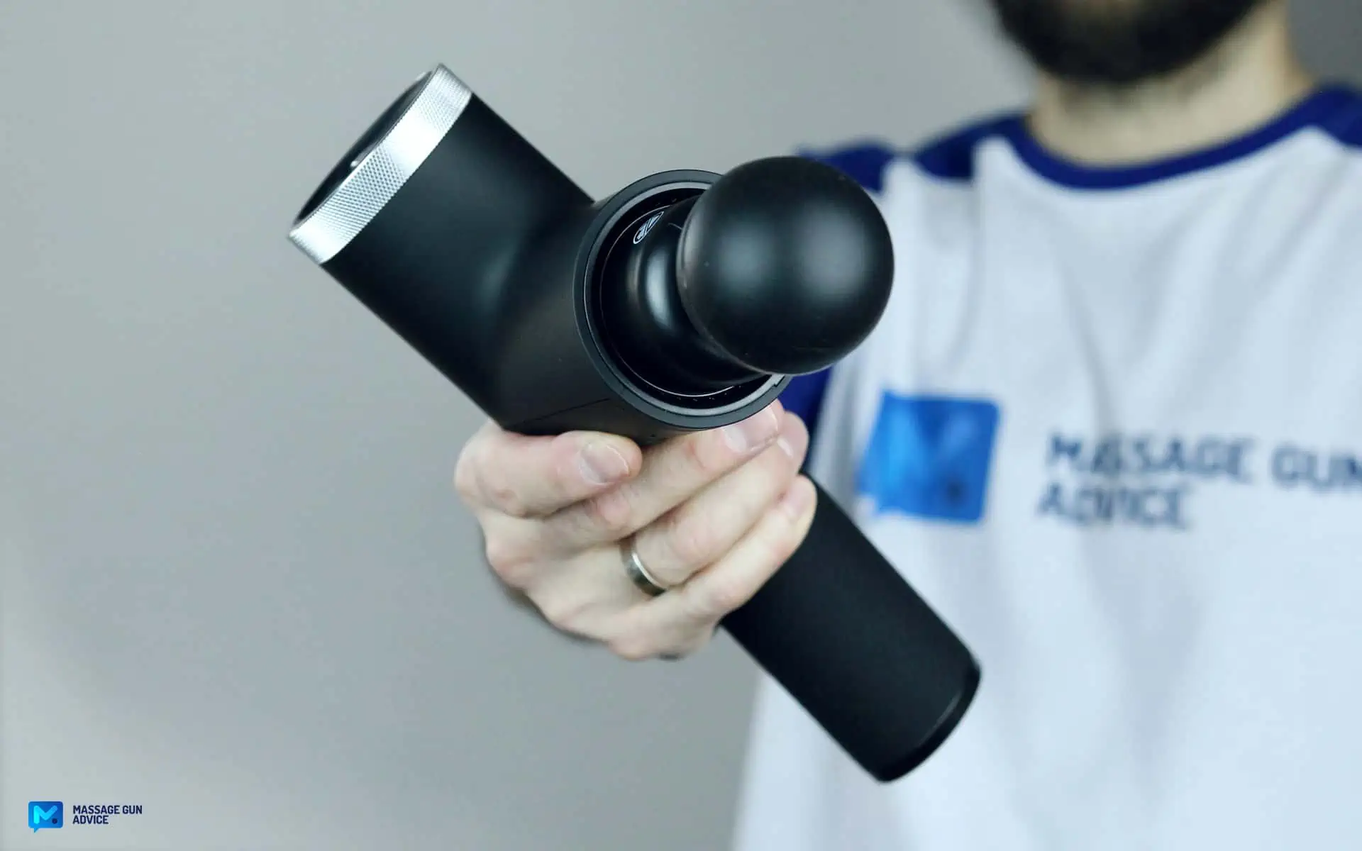 Ekrin Kestrel Review - Is This the Ultimate Massage Gun Unicorn? 36 ekrin Kestrel held by a man on blurred background